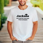 Gepersonaliseerde naam Witte Klasse van 2025 Afstu T-shirt<br><div class="desc">Het moderne, witte T-shirt met aangepast afstuderen is voorzien van de voornaam van de afgestudeerde in vetgedrukte zwarte decoratieve stijl met een afstudeerder pet accent (kan indien nodig worden hergeplaatst) en een minimale klassejaar en schoolnaamvermelding die kan worden aangepast aan de informatie van uw afstudeerder. De kleuren en stijl van...</div>
