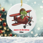 Gepersonaliseerde, Schattigee Vliegtuigdinosaurus, Keramisch Ornament<br><div class="desc">Het ontwerp is voorzien van een schattige dinosaurus met een pilotenhelm die met een rood vliegtuig vliegt. Onderaan het afbeelding staat de tekst '[Naam] 1e Kerst' en jaar. Pas dit ornament aan met uw specifieke gegevens. Dit zou perfect zijn voor die kleine vliegenier! Copyright Soar in Style Design LLC.</div>