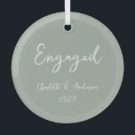 Gepersonaliseerde verloofde paar handgeschreven sa glas ornament<br><div class="desc">Vier je eerste kerst als een verloofd stel met dit gepersonaliseerde glazen ornament, met een grillig handgeschreven script in het wit op een salie groene achtergrond. Het elegante maar speelse ontwerp voegt een vleugje charme en sophisticatie toe aan uw vakantiedecor, waardoor het een perfecte herinnering is voor deze speciale mijlpaal....</div>