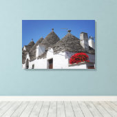 Geraniumbloemen en boomgaarden in Alberobello Canvas Afdruk (Insitu (Houten vloer))