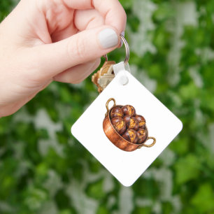 Geroosterde kastanjes in een koperen pan sleutelhanger