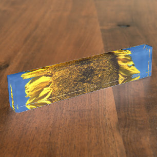 geschilderde grote gele zonnebloem tegen een blauw naambordje