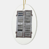 Gesloten venster met oude houten luiken keramisch ornament (Links)