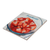 Gesneden rode aardbeien in kom fotografisch grijs tegeltje (Zijkant)