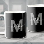 Glamoureus zwart-wit naam monogram koffiemok<br><div class="desc">Gepersonaliseerde moderne zwart-wit Initiaal scriptnaam Monogram Coffee Mok. Deze stijlvolle monogram mok combineert een moderne minimalistische stijl met een eenvoudige maar stijlvolle look, ideaal voor elke koffie- of theeliefhebber. Met een vet grijs initiaal op een zwarte achtergrond en een witte scriptnaam, heeft deze mok het monogram aan beide zijden weergegeven,...</div>