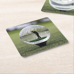 Glazen golfbal met golfspeler binnen, kartonnen onderzetters