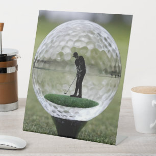 Glazen golfbal met golfspeler binnen, reclamebord met voetstuk