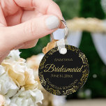 Gold Frills op Black Bridesmaid Wedding Gift Sleutelhanger<br><div class="desc">Deze sleutelhangers zijn ontworpen om bruidsmeisjes in je bruiloft te bevoordelen. Ze hebben een eenvoudig, maar elegant ontwerp met een klassieke zwarte achtergrond, gouden scriptletters en een lacy golden faux folie floral border. De tekst zegt "Bridesmaid" met ruimte voor haar naam, de namen van het paar en de trouwdatum. De...</div>
