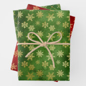 Gold kerstsnowflakes op rood en groen inpakpapier vel (In situ)