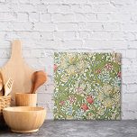 Golden Lily WildbloWilliam Morris Tegeltje<br><div class="desc">Een decoratieve keramische tegel met een bloempatroon dat oorspronkelijk was ontworpen door de Britse kunstenaar William Morris uit de Arts and Crafts-periode. Goudnaaide leugens met rode en blauwe wilde bloemen.</div>