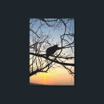 Golden Sunset Silhouette: Bird on Tree Branches Canvas Afdruk<br><div class="desc">Capture the serene beauty of twilight with this stunning silhouette photograph. A lone bird rests among the intricate web of bare tree branches, set against a vibrant golden and blue sunset sky. The high contrast and natural geometry create a peaceful, artistic atmosphere that complements any modern decor. This design is...</div>