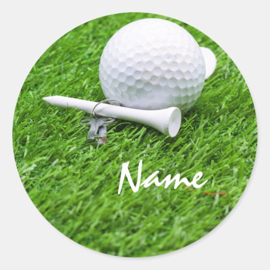 Golfbal en t-shirt op groen gras ronde sticker (Voorkant)