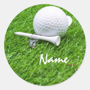 Golfbal en t-shirt op groen gras ronde sticker