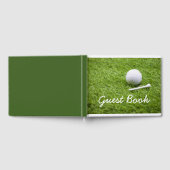 Golfbal en wit t-shirt zijn op groene grasgolfer gastenboek (Volledig)