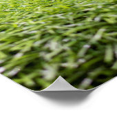 Golfbal ligt op t-shirt op groene grasachtergrond poster (Hoek)