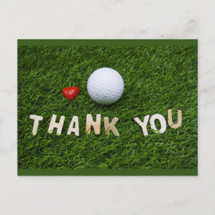 Golfbal met bedankt woord op groen gras briefkaart