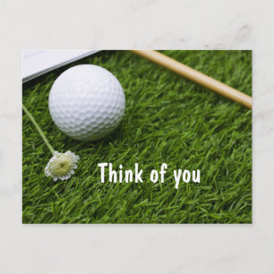 Golfbal met een kleine bloem op gras denk aan U Briefkaart