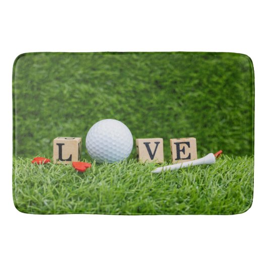 Golfbal met LOVE-woord en t-shirt op groen gras Badmat (Voorkant)