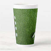 Golfballen liggen op groen gras latte mok (Voorkant)
