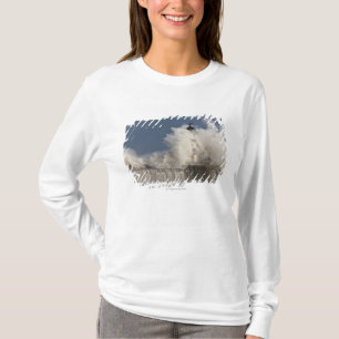 Golven kruipen tegen een vuurtoren t-shirt