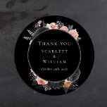Gothic  zwart blush bruiloft dank u ronde sticker<br><div class="desc">Deze gotische zwarte blush bruiloft dank u klassieke ronde sticker is een donker canvas van romance en tijdloze elegantie. Dit ontwerp heeft traditionele motieven verweven met een humeurige esthetiek die doet denken aan de herfst. Fijne waterverf stoffige roos en donkerblush bloemenarrangementen dansen over het zwarte doek en roepen de etherische...</div>