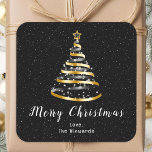 Goud en zwart lint — Merry kerst Vierkante Sticker<br><div class="desc">Deze elegante en chique vakantie sticker kan worden gepersonaliseerd met uw familienaam. Het ontwerp is voorzien van een gouden en zwarte kerstboom met een stertopper. De tekst combineert handgeschreven script en moderne schreefloze lettertypen voor een stijlvolle en verfijnde look. De vallende sneeuw, sneeuwvlokken en schitteringen geven een feestelijke en magische...</div>