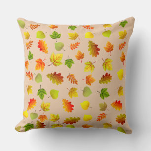 Gouden, groene, oranje herfstbladeren op beige kussen