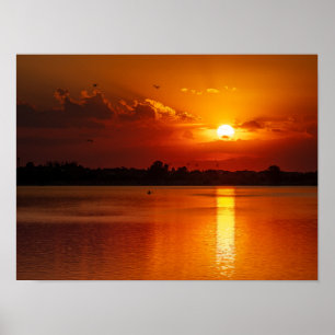 Gouden oranje zonsondergang boven een kalm meer poster
