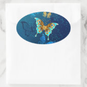 Gouden vlinders op een blauwe achtergrond ovale sticker (Tas)