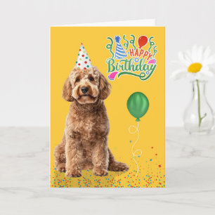 Goudendoodle-hond in een feesthoed op gele verjaar kaart