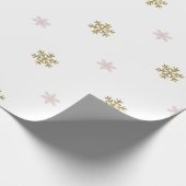 Goudglitter en roze sneeuwvlokken op witte kerst cadeaupapier (Hoek)