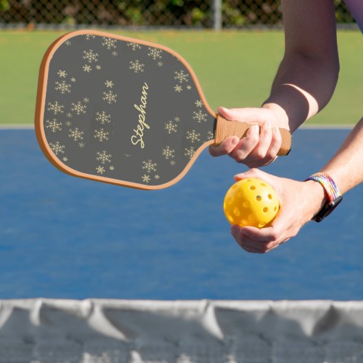 Goudsneeuwvlokken op grijs pickleball paddle (Insitu)