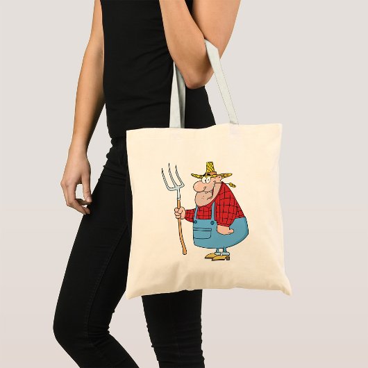 Grappige boer met hooivork overall en strohoed tote bag