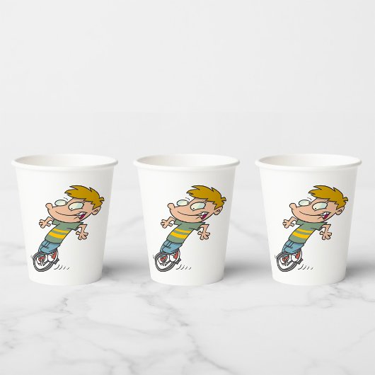 Grappige jongen die eenwieler rijdt papieren bekers