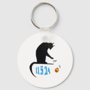 Grappige kat die Sinaasappel van tafel veegt op ve Sleutelhanger