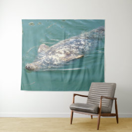 Grappige lieve zeehond drijft op rug in oceaan wan wandkleed