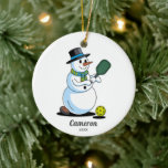 Grappige Pickleball Snowman, voeg aangepaste foto  Keramisch Ornament<br><div class="desc">Een super leuk pickleball kerstornament met een sneeuwman die pickleball speelt. Voeg uw aangepaste tekst toe aan de voorkant en pickleball-spelersfoto aan de achterkant. Het is het perfecte vakantiegeschenk voor uw pickleball-partner,  geheime kerstman,  coach,  teamcoördinator of iedereen die van deze geweldige sport houdt.</div>