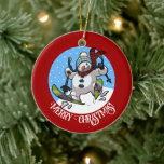 Grappige sneeuwman vrolijk kerstfeest! Cartoon Keramisch Ornament<br><div class="desc">Een vrolijke sneeuwpop op een keramisch ornament voor je kerstboom. Gebruik "Personaliseer deze sjabloon" om de "Merry Christmas!"-tekst aan te passen en creëer een uniek, aangepast cadeau te geven. Met een schattige sneeuwman met een wortelneus en kolenogen, die door de sneeuw op ski's raast, in wollig winterse pet en tartan...</div>
