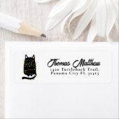 Grappige zwarte kat verstrikt in kerstlicht etiket (Insitu)