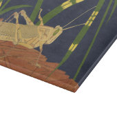 Grasshopping in groene gras op blauwe achtergrond snijplank (Hoek)