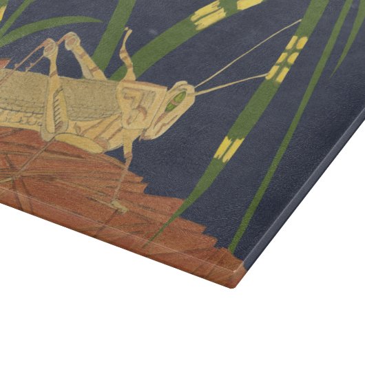 Grasshopping in groene gras op blauwe achtergrond snijplank (Hoek)