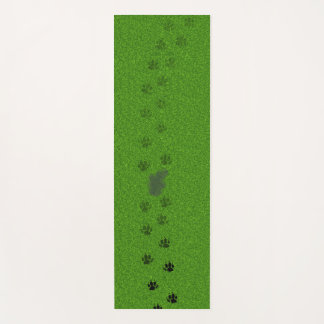 Green grass with dog paw prints and a pee stain yogamat
