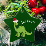 Green Kerstmis Kinder Dinosaur Keramisch Ornament<br><div class="desc">Geweldige groene dinosaurus glimlacht en ziet er erg schattig uit in een feestelijke rode kersthoed. Ik hou van prehistorische kerstdieren en cadeaus waar kinderen van zullen houden. Pas dit geschenk met de naam van de ontvanger aan om het nog meer gepersonaliseerd te maken.</div>