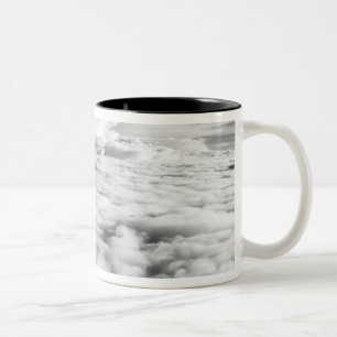 Griezelig wolkenlandschap bij zonsopgang. 2 tweekleurige koffiemok