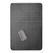 Grijze balkzeep op een zwarte tapijten badmat (Voorkant Verticaal)