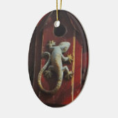 grijze hagedis op versleten hout keramisch ornament (Links)