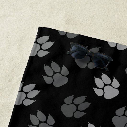 Grijze verf afdrukken op zwart met monogram en naa strandlaken (In situ)