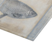 Grijze vis op beige achtergrond snijplank (Hoek)