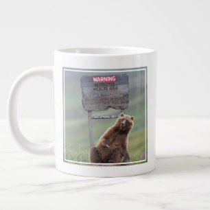 Grizzlybeer speelt met bord grote koffiekop