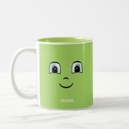 Groen gelukkig gezicht met veganistische tekst en tweekleurige koffiemok
